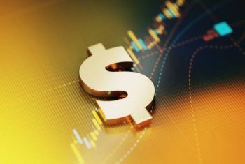 Gold colored American dollar sign sitting on yellow financial graph background. Horizontal composition with selective focus and copy space. Investment, stock market data and finance concept.